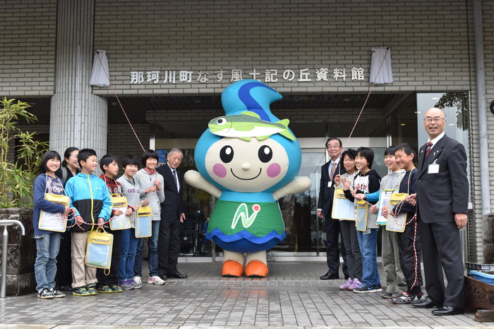 風土記の丘資料館オープニング除幕式で笑顔の子どもたちとなかちゃんの写真 風土記の丘資料館オープニング除幕式で笑顔の子どもたちとなかちゃんの写真