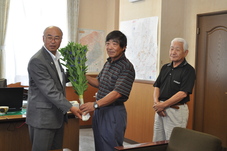 町長にリンドウの贈呈をしている写真