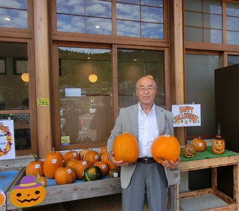 かぼちゃを2つ抱える町長の写真
