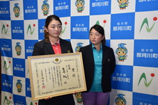 賞状を持つ姉と横に立つ妹の写真 賞状を持つ姉と横に立つ妹の写真