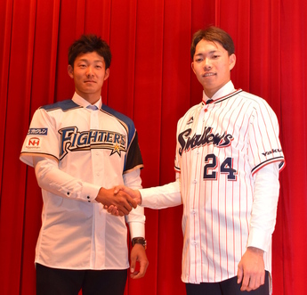 ユニホーム姿で握手をする石井選手と星選手の写真