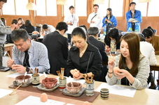 素焼きのフクロウに絵付けをしている参加者たちの写真