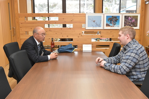 町長と外国人男性（マイク スーイさん）が話している写真