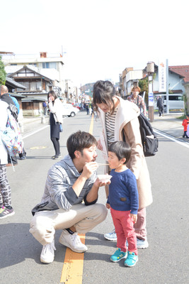 子どもに食べ物を食べさせている父親の写真