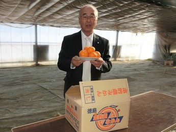 みかんを持つ町長の写真