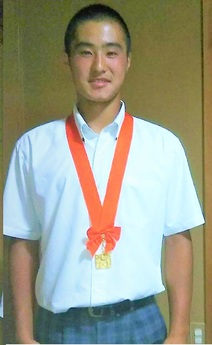 金メダルを首にかけている石井選手の写真