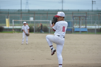 投手がマウンドで足を上げボールを投げる態勢の写真