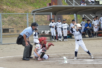 打席の左から主審、那珂クラブの捕手、相手チームの打者の横姿の写真