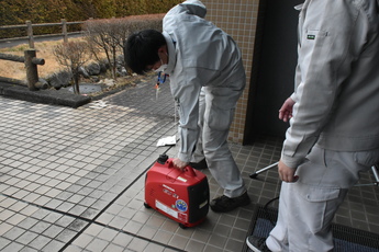 発電機の始動を体験する男性職員の写真