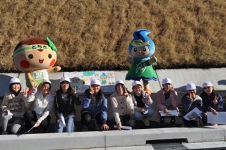 児童たちが描いた絵の前での記念写真