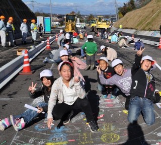 道路にチョークで絵を描く子どもたちの写真