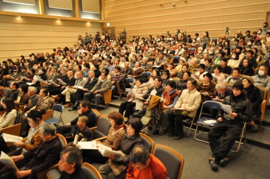 「ふるさと」を歌う観客たちの写真