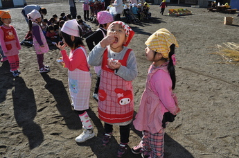 おもちをほお張る園児の写真