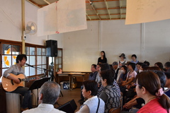 弾き語りでライブをしている男性の写真