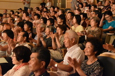 拍手をする観客たちの写真