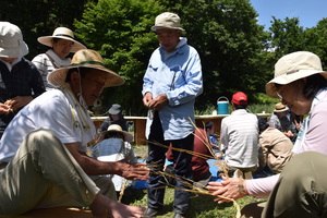 藁でどろだんごを乗せる台を作っている写真
