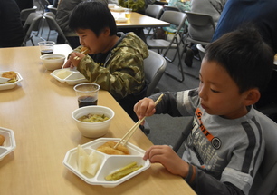 収穫祭で食事をする園児の写真