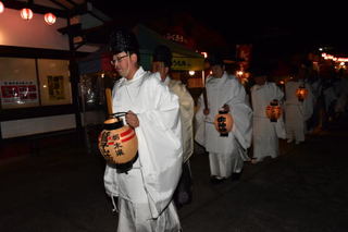 提灯を持って歩く氏子の写真