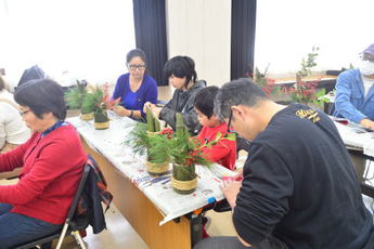 親子でミニ門松を作っている写真