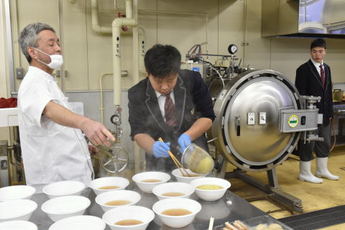 麺をスープに入れている写真