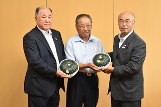 かぼちゃを持つ3人の男性の写真