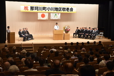 祝いの言葉を述べる人の写真