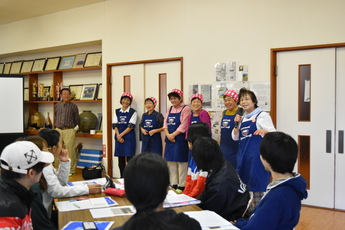 学生に向けて話をする女性たちの写真