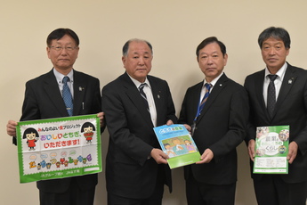 贈呈品を持つ4人の男性の写真 贈呈品を持つ4人の男性の写真