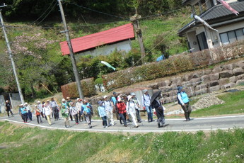 里山を歩く人々の写真