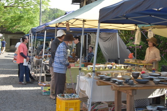小砂陶器市(お客さんと陶芸作家の方が楽しそうに会話する写真)