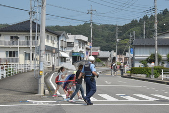 避難訓練の大雨を想定して傘をさして避難する住民の写真