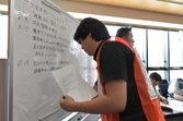 避難訓練でホワイトボードに被害状況を書き込んでいる写真