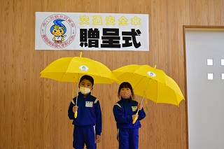 黄色い傘を持つ2人の小学1年生の写真