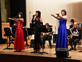 歌を歌う3人の女性の写真