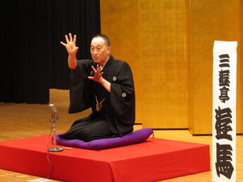 身振り手振りをして落語を披露する落語家の写真