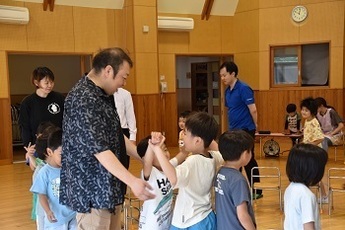 椅子取りゲームをする園児と商工会職員の写真