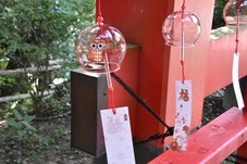 赤いフクロウが描かれた薄赤い風鈴の写真