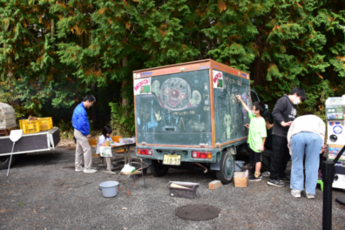 荷台が黒板になっているトラックに絵を描く参加者の写真