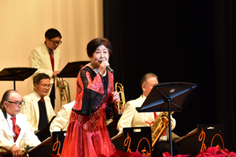 赤い衣装を着て歌う女性の写真