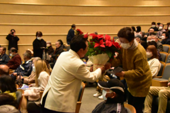 抽選会で当選者に花束を渡している写真