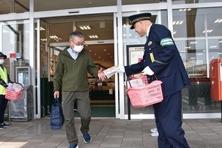 交通安全のチラシを配る警察官の写真