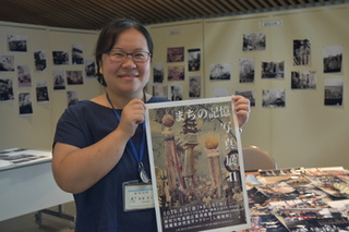 まちの記憶写真展Ⅱのポスターを持つ那珂川町地域おこし協力隊の齋藤悠子隊員