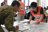 避難訓練で地図を見ながら被害状況を確認する自衛隊員