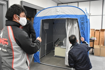 テント内に仮設トイレを設置する男性職員