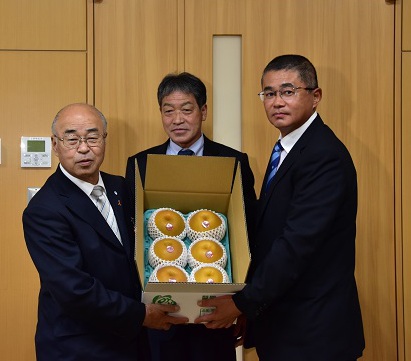 ６個の梨が入った箱を持つ左から町長、中山組合長、平塚副部会長
